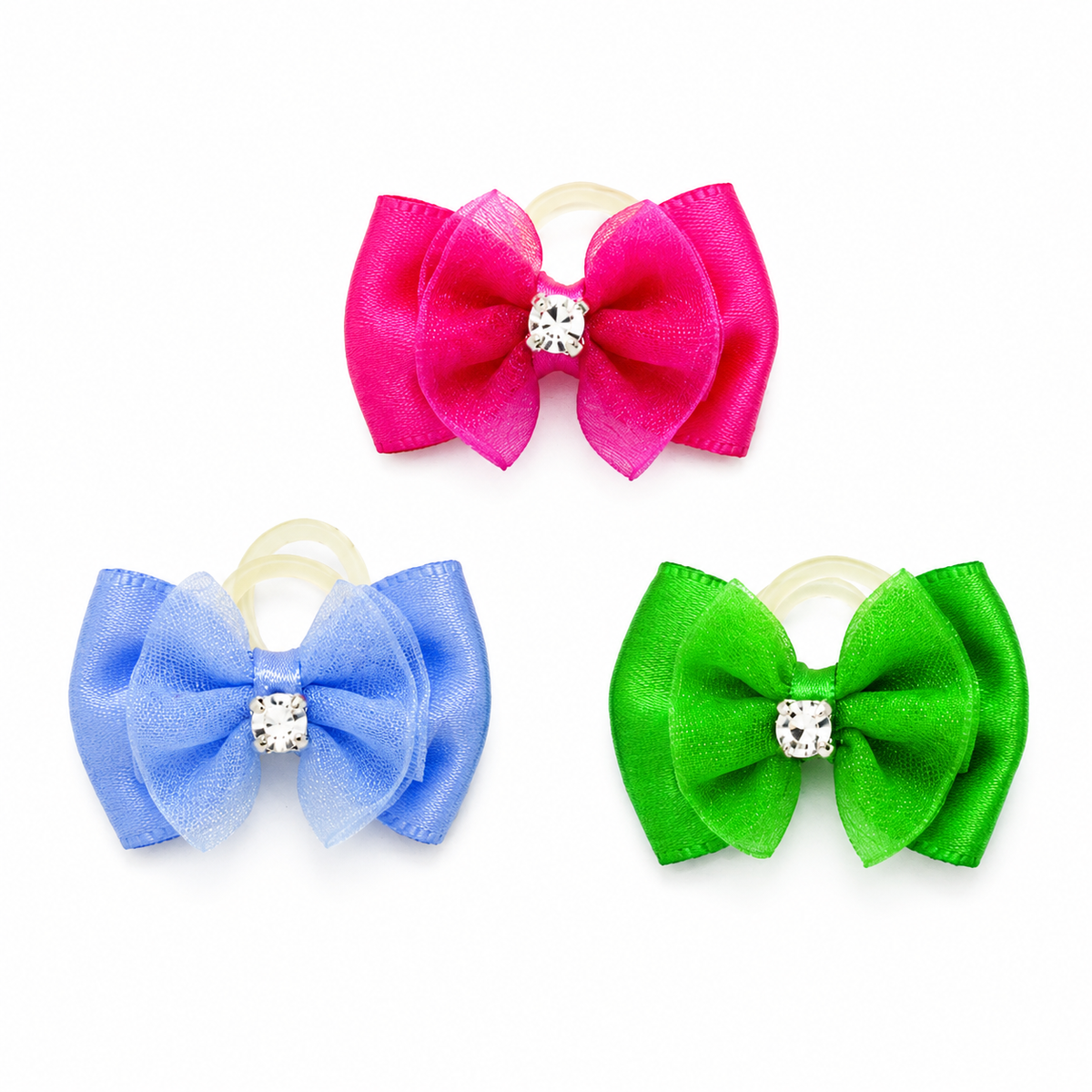 Three hair bows in bright pink, light blue, and green, each with a small clear rhinestone center and a beige elastic loop, shown on a white background.