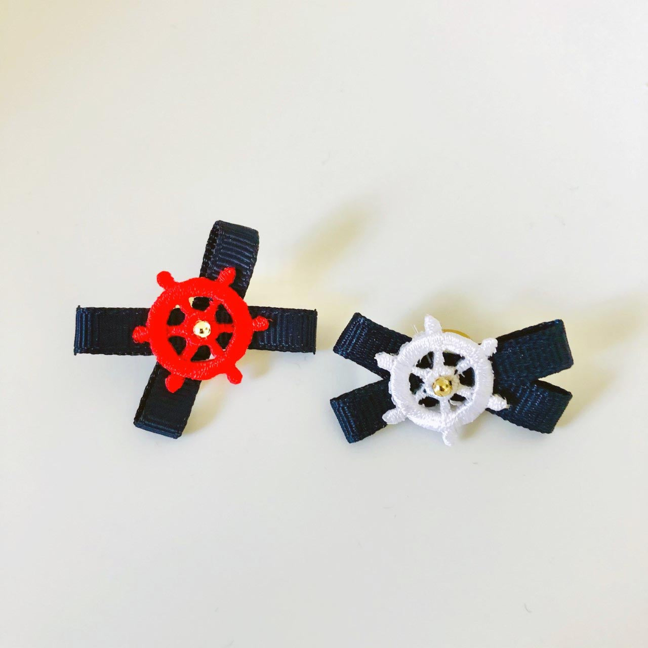 Ships Wheels in 2 colors on navy grosgrain with cetner gold bead